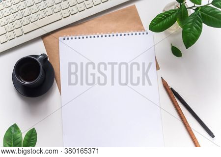 Desk With Keyboard And Coffee And A Notebook