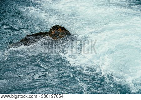 Mossy Stone In Azure Water Of Mountain River Close-up. Blue Nature Background With Boulder With Moss