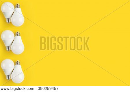 Light Bulbs Of A White Matte Color On A Yellow Background. The Concept Of Electricity. Minimalist Co