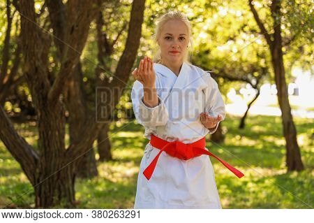 Young Woman Dressed In Kimono Practicing Her Karate Moves In Park - Red Belt