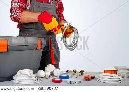 Electrician Engineer Works With Electric Cable Wires Of House. Electrical Equipment. Copy Space.