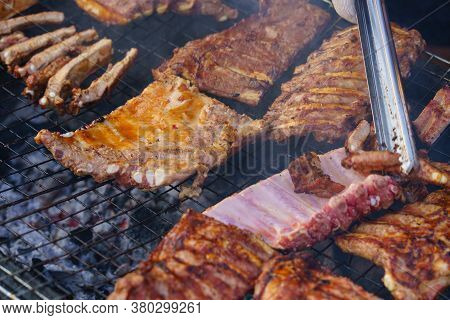 Grilled pork ribs on the grill or BBQ at street food market.
