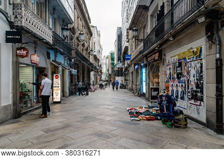 Corunna, Spain - July 20, 2020: View Of Migrant Street Vendors In Pedestrian Shopping Street In City