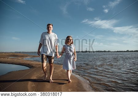 Couple In Love On The Beach.young Man And Woman Walking On Seashore And Laughing.