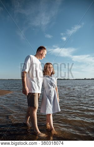 Couple In Love On The Beach.young Man And Woman Walking On Seashore And Laughing.