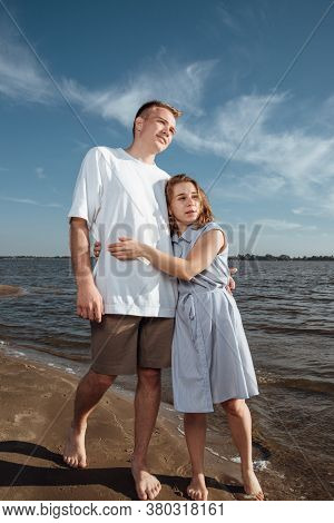 Couple In Love On The Beach.portrait Of A Couple In Love On The Beach. A Young Girl Hugs A Guy.