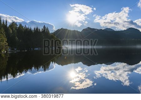 Beautiful Blue Lake With Surrounding Mountains Reflecting Back