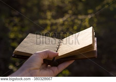 Opened Old Book With Reflected In Black Surface.