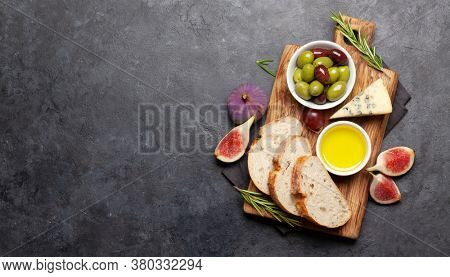 Ripe olives, olive oil, figs and ciabatta bread. Top view flat lay with copy space