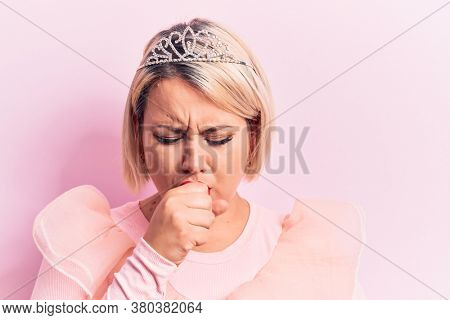 Beautiful blonde plus size woman wearing pincess tiara with diamonds over pink background feeling unwell and coughing as symptom for cold or bronchitis. Health care concept.