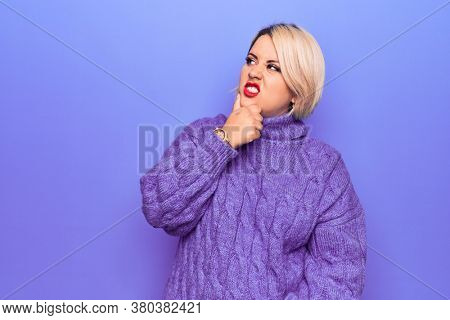 Beautiful blonde plus size woman wearing casual turtleneck sweater over purple background Thinking worried about a question, concerned and nervous with hand on chin