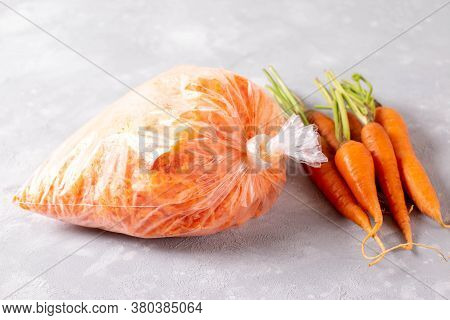 Frozen Grated Carrots In Plastic Bags On A Light Background. Frozen Vegetables