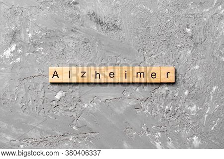 Alzheimer Word Written On Wood Block. Alzheimer Text On Cement Table For Your Desing, Concept