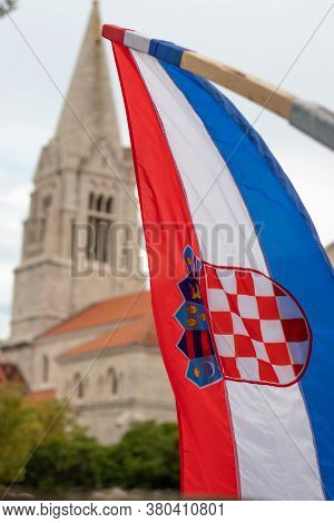 Closeup Of The Croatian Flag Waving In The Wind With The Church In The Village Of Selca, Croatia In 