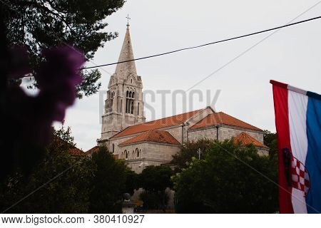 Closeup Of The Croatian Flag Waving In The Wind With The Church In The Village Of Selca, Croatia In 