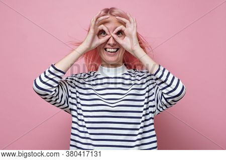 Girl Holding Fingers Near Eyes Like Glasses: Mask Like Super Hero. Showing Ok Gesture.