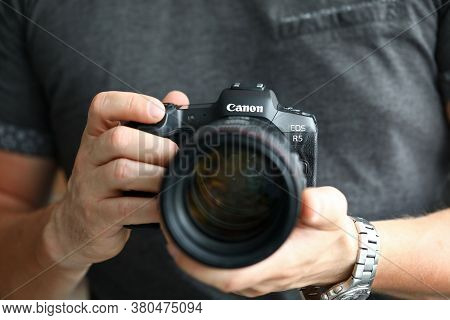 Barcelona, Spain - July 31, 2020: Male Hand Holding Brand New Mirrorless Digital Camera Canon R5 Clo