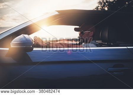 Caucasian Men In His 40s In Baseball Hat And Sunglasses Enjoying Drive His Modern Convertible Car. D