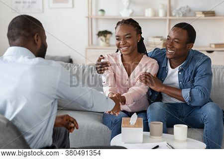 After Effective Therapy. Joyful Black Couple Handshaking With Marital Counselor After Session, Sitti