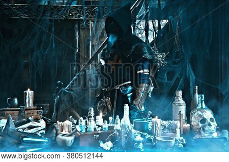 The plague doctor is working at his desk, inventing a cure for bubonic plague. The atmosphere of mysticism. Historical reenactment. Halloween. 