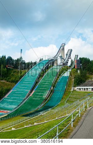 Lahti, Finland - 4 August 2020: Lahti Sports Centre With Three Ski Jump Towers. Sportsman Is Jumping