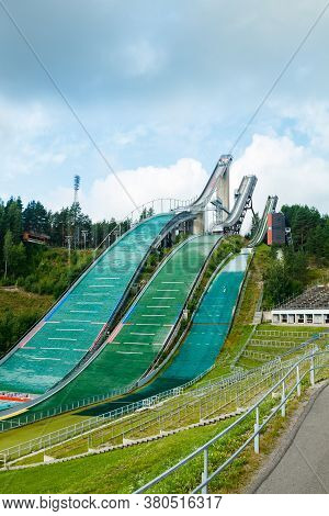 Lahti, Finland - 4 August 2020: Lahti Sports Centre With Three Ski Jump Towers. Sportsman Is Jumping