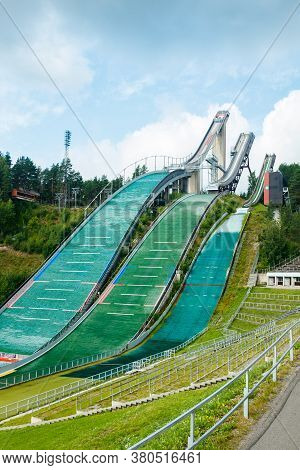 Lahti, Finland - 4 August 2020: Lahti Sports Centre With Three Ski Jump Towers. Sportsman Is Jumping