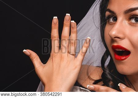 Close-up Of An Attractive Bride, In A Veil And Wedding Dress, Showing Her Hand With An Engagement Ri