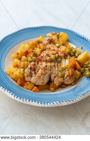 Chicken Thighs With Potato, Carrot And Green Peas Served In Plate For One Portion