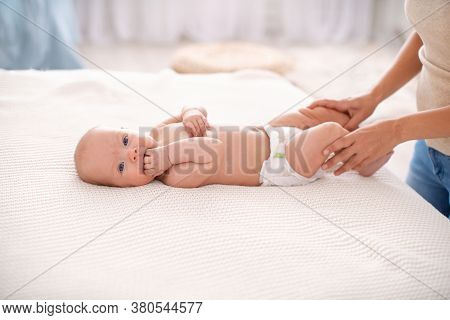 Baby Massage. Masseur Massaging Belly Of Baby During Colic. Newborn Colicky Baby Without Clothes Lay
