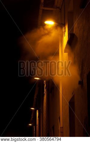 Illuminated street lights in the fog at night. Sabinanigo. Huesca. Aragon. Spain.