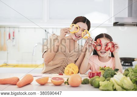 Happy Mother And Child Daughter  Preparing The Vegetables And Fruit
