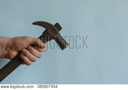 Locksmiths Hand Holds A Vintage Hammer With A Claw Hammer. Male Hand With A Hammer With A Long Woode