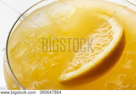 High Angle View Macro Detail Of Slice Of Orange Floating In Crushed Ice Of Orange Margarita Cocktail