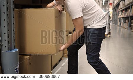 Warehouse Large Storage Or Logistic Or Cargo For Distribution. And Man's Hand Is Picking Up A Box.