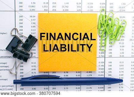Text Financial Liability On Financial Tables With Pen And Paper Clips