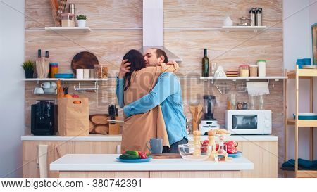 Cheerful Couple Smiling And Dancing In Kitchen. Romantic Husband And Wife. Cheerful Happy Young Fami