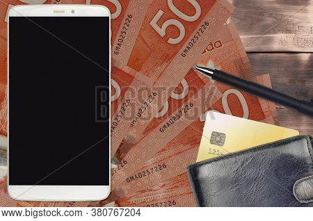 50 Canadian Dollars Bills And Smartphone With Purse And Credit Card. E-payments Or E-commerce Concep