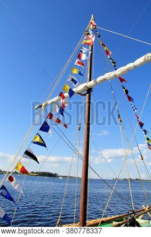 Sea Signal Flags Mounted On The Mast Against The Blue Sky, Taken Close-up. Ship's Flags Fluttering I