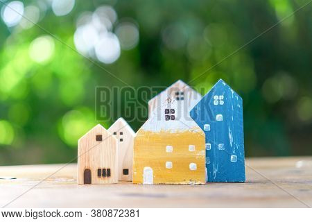 Closed Up Tiny Home Model On Floor Or Wood Board With Sunlight Green Bokeh Background. House Propert