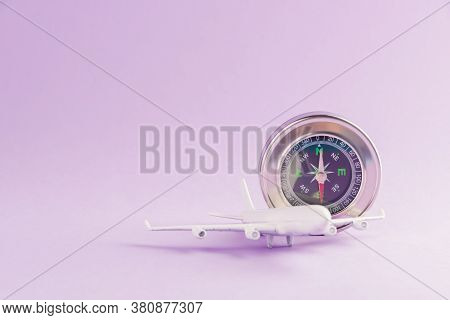 World Tourism Day, Minimal Toy Model Plane And Compass, Studio Shot Isolated On A Purple Background 