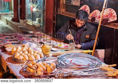 Luoyang, Henan Province / China - January 3, 2016: Man Making And Selling Traditional Handicrafts In
