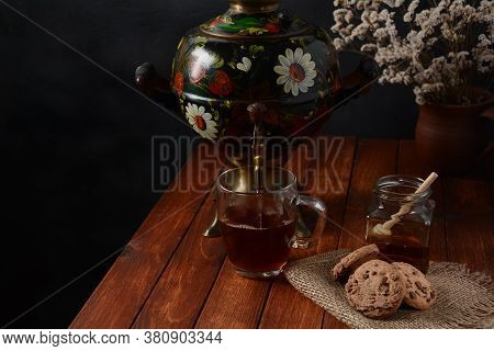 Tea Party In Rustic Style With Samovar\na Glass In Glass Holder, Honey And Cookies