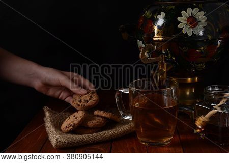 A Girl With Cookie In Hand. Samovar
A Jar With Tea, Honey And Cookies.