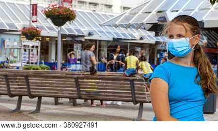 A Young Girl Wears A Face Mask On The Streets Of The City.cute Teenage Girl With A Surgical Mask On 
