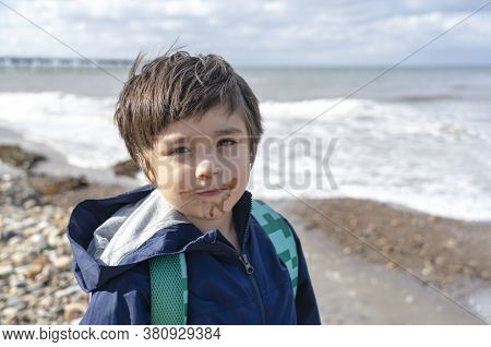 Head Shot Kid With Dirty Mouth Of Chocolate Ice Cream With Blurry Sea View Background,candid Shot Ha