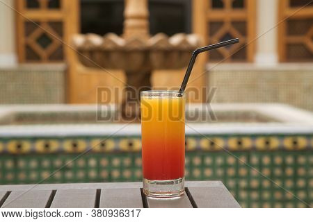 Glass Of Orange Juice With Syrup In A Glass On A Green Background