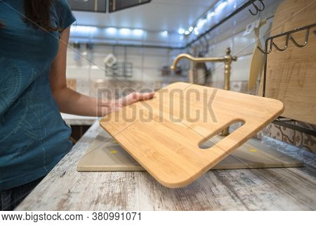 Woman Is Choosing A New Cutting Board For Kitchen Close Up.