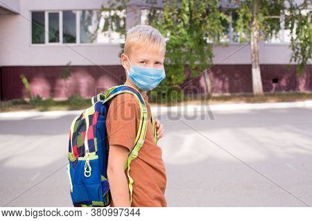 Back To School. School-age Boy With A Protective Medical Mask On Her On His Face With A School Backp