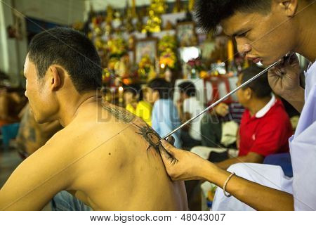 NAKHON CHAI, Tajlandia - MAR 23: Niezidentyfikowane mnich sprawia, że tradycyjne Yantra tatuażu w Wai pełna